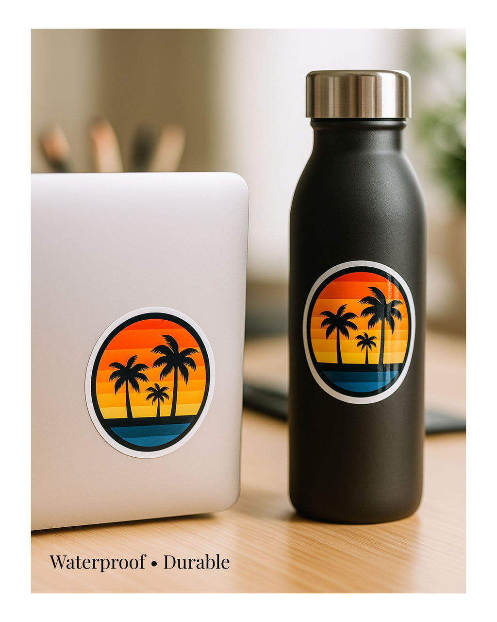 Black water bottle with palm tree design next to a laptop on a wooden surface.
