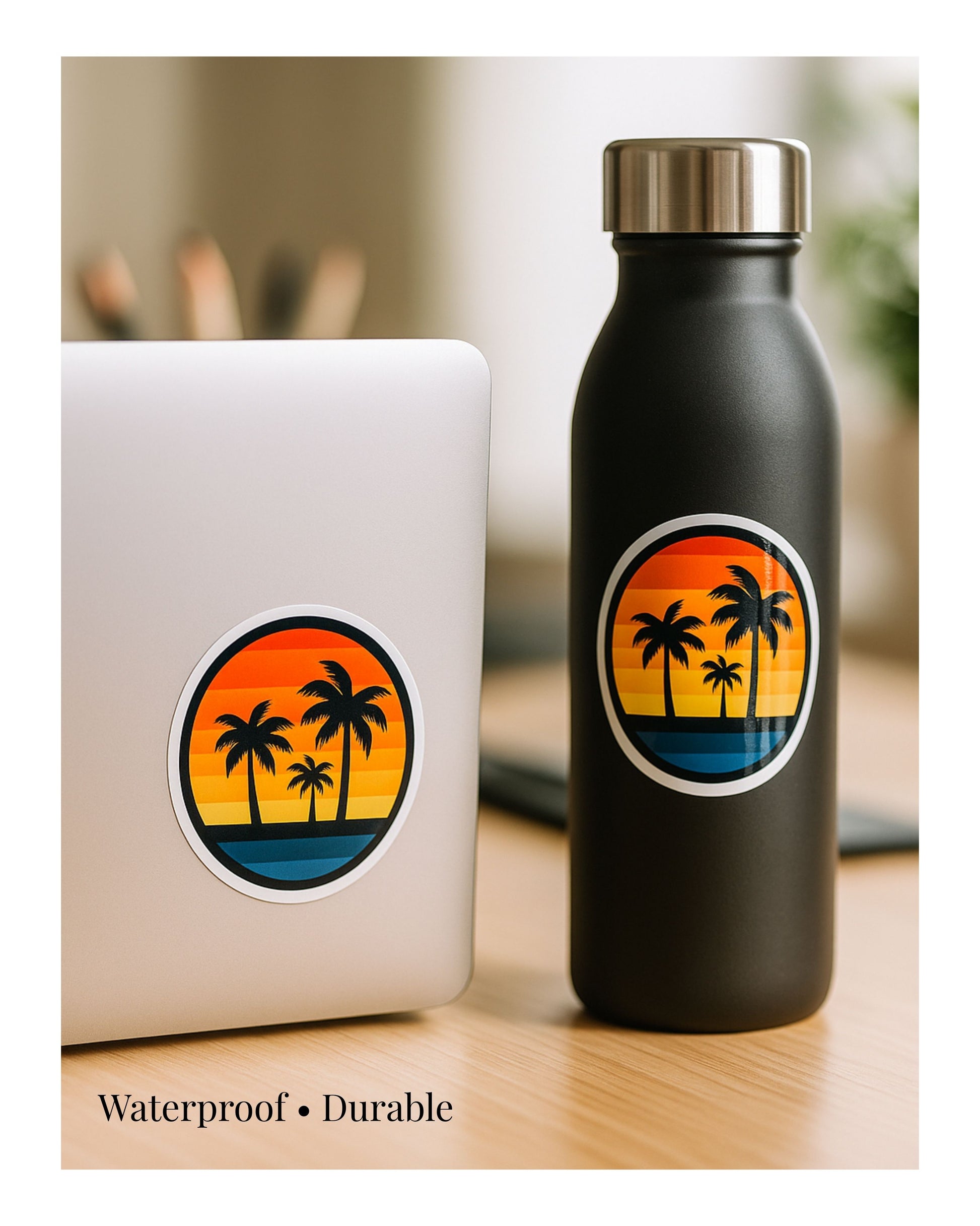 Black water bottle with palm tree design next to a laptop on a wooden surface.